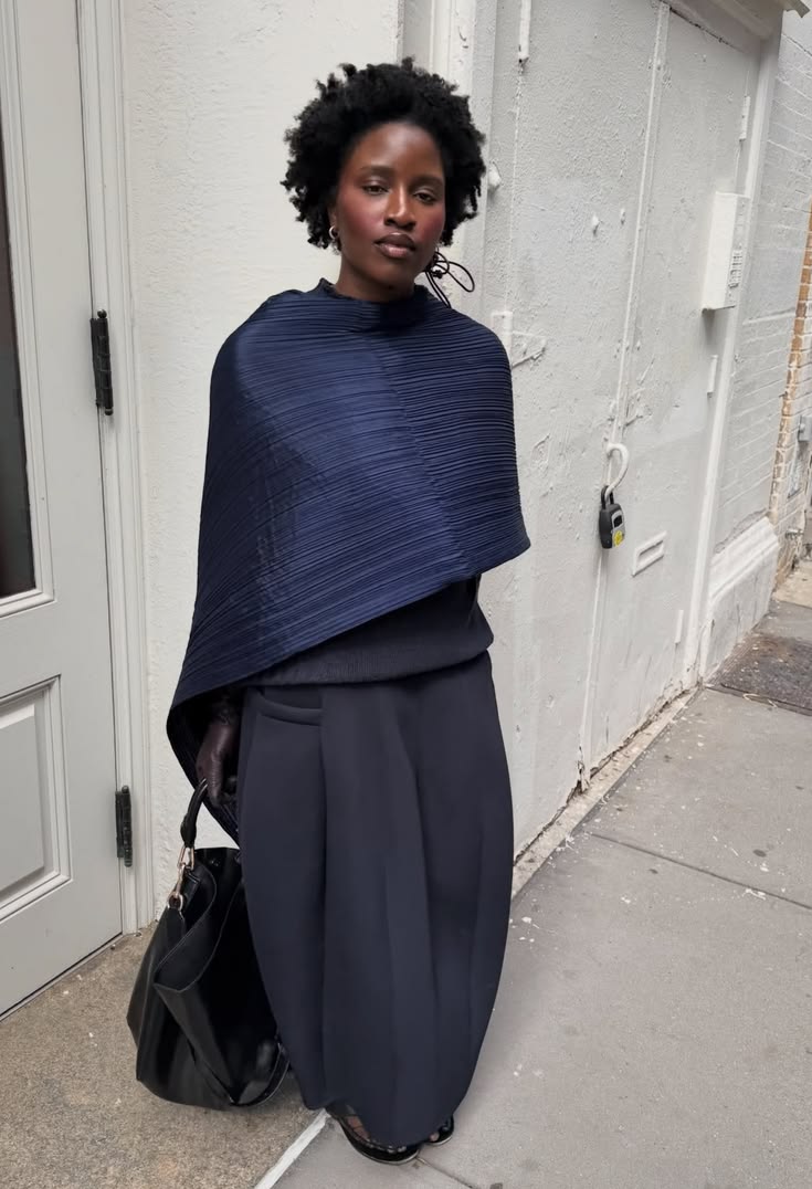 Navy pleated wrap over a dark knit and wide trousers on a New York street